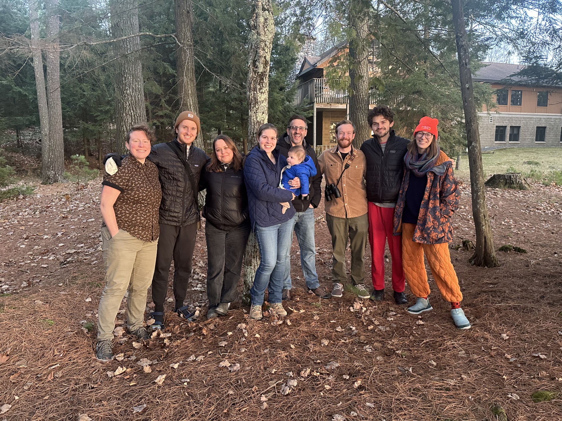 Group photo with trees and research station in the background